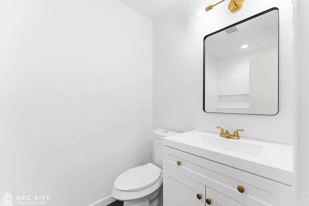 4015 37th Street Lubbock, TX 79413 - Photo 24 of 30 a bathroom with a toilet sink vanity and mirror