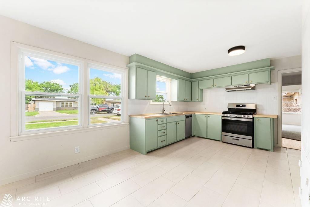 4015 37th Street Lubbock, TX 79413 - Photo 4 of 30 a kitchen with a stove a sink and a microwave