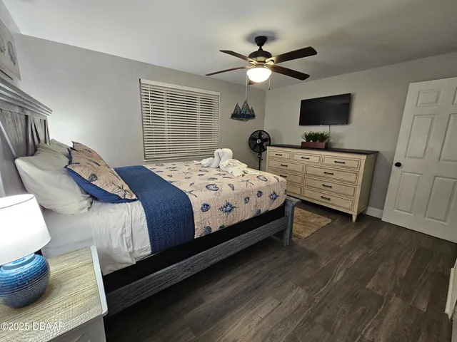a bedroom with a bed and a flat screen tv