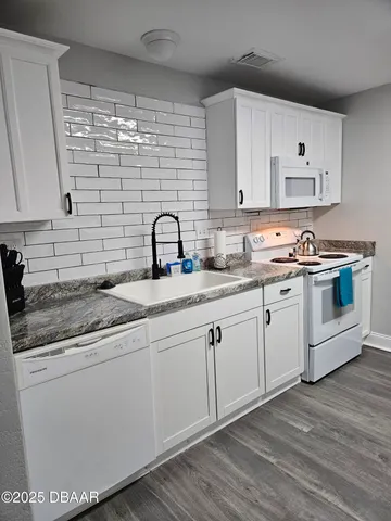 a kitchen with a sink cabinets and wooden floor