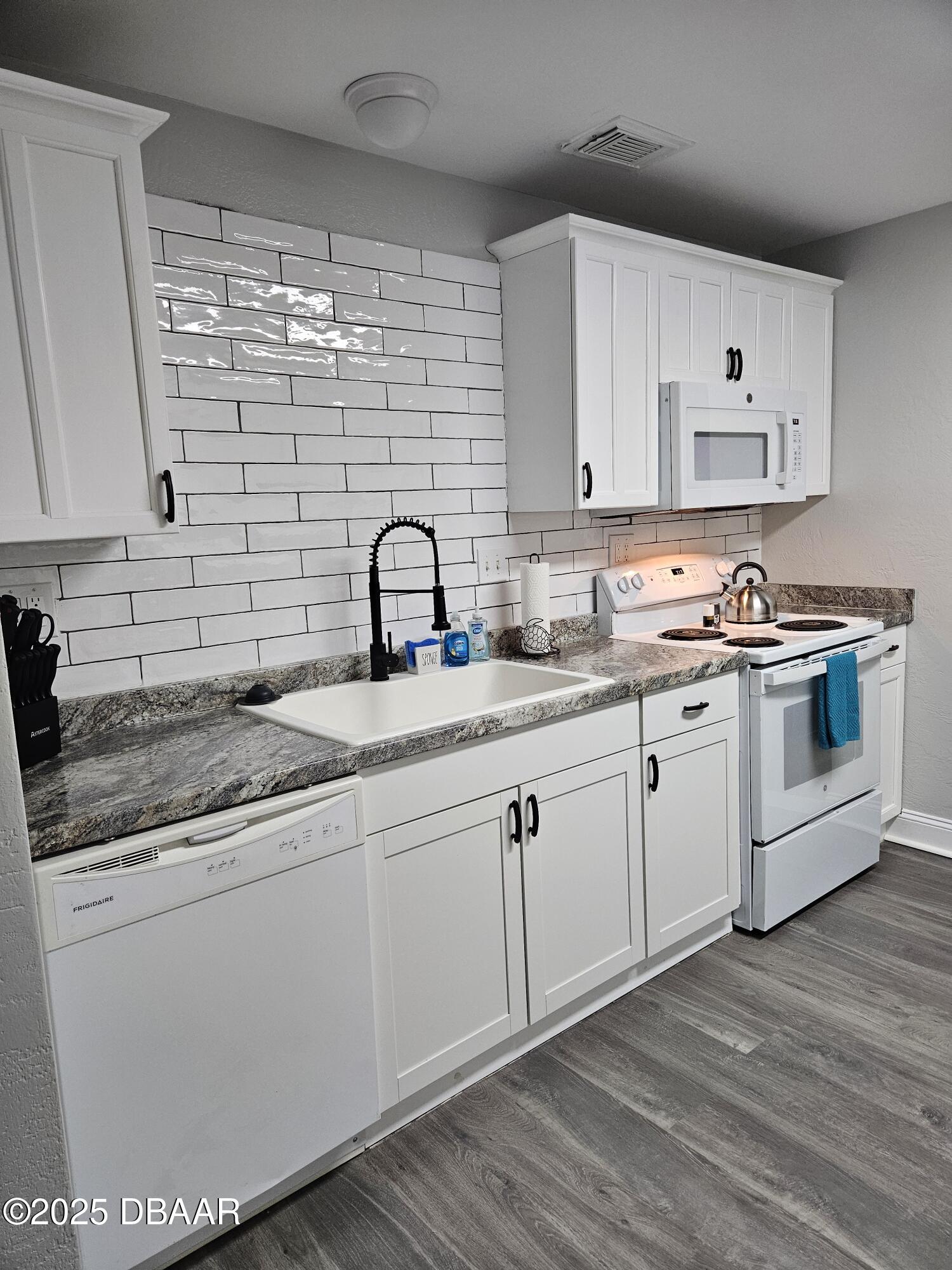 62 Rivershore Drive Ormond Beach, FL 32176 - Photo 7 of 27 a kitchen with a sink cabinets and wooden floor