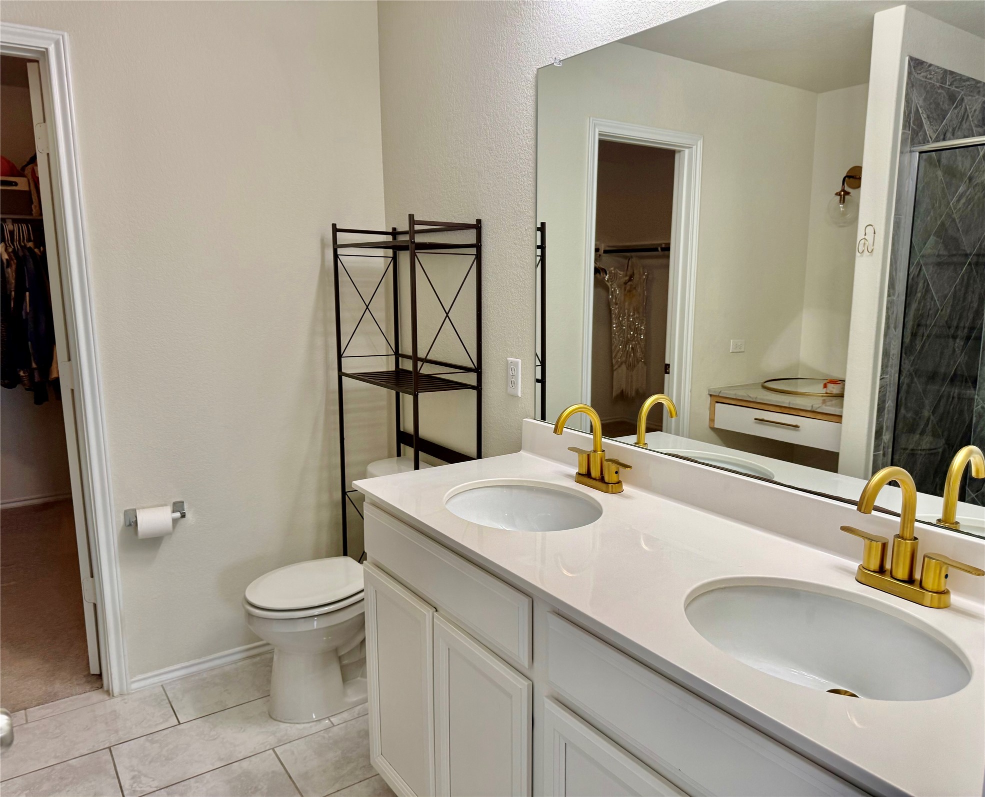 1017 Cliffbrake Way Georgetown, TX 78626 - Photo 14 of 21 Bathroom with a spacious closet, double vanity, light tile patterned floors, and a stall shower