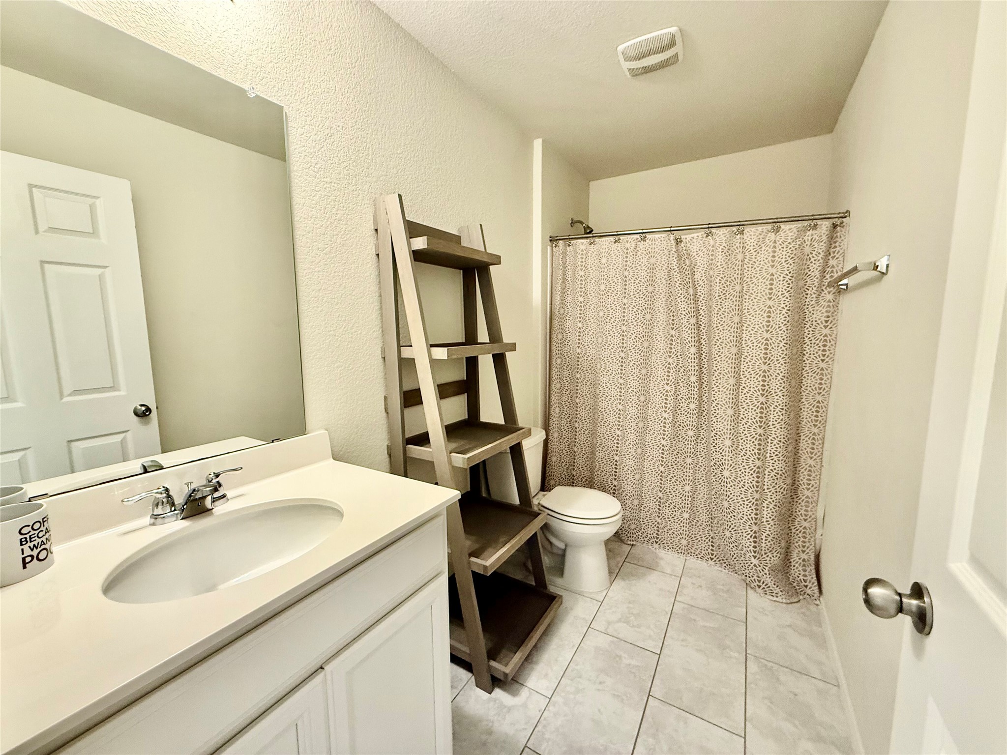 1017 Cliffbrake Way Georgetown, TX 78626 - Photo 19 of 21 Full bathroom with vanity, curtained shower, a textured wall, and light tile patterned floors