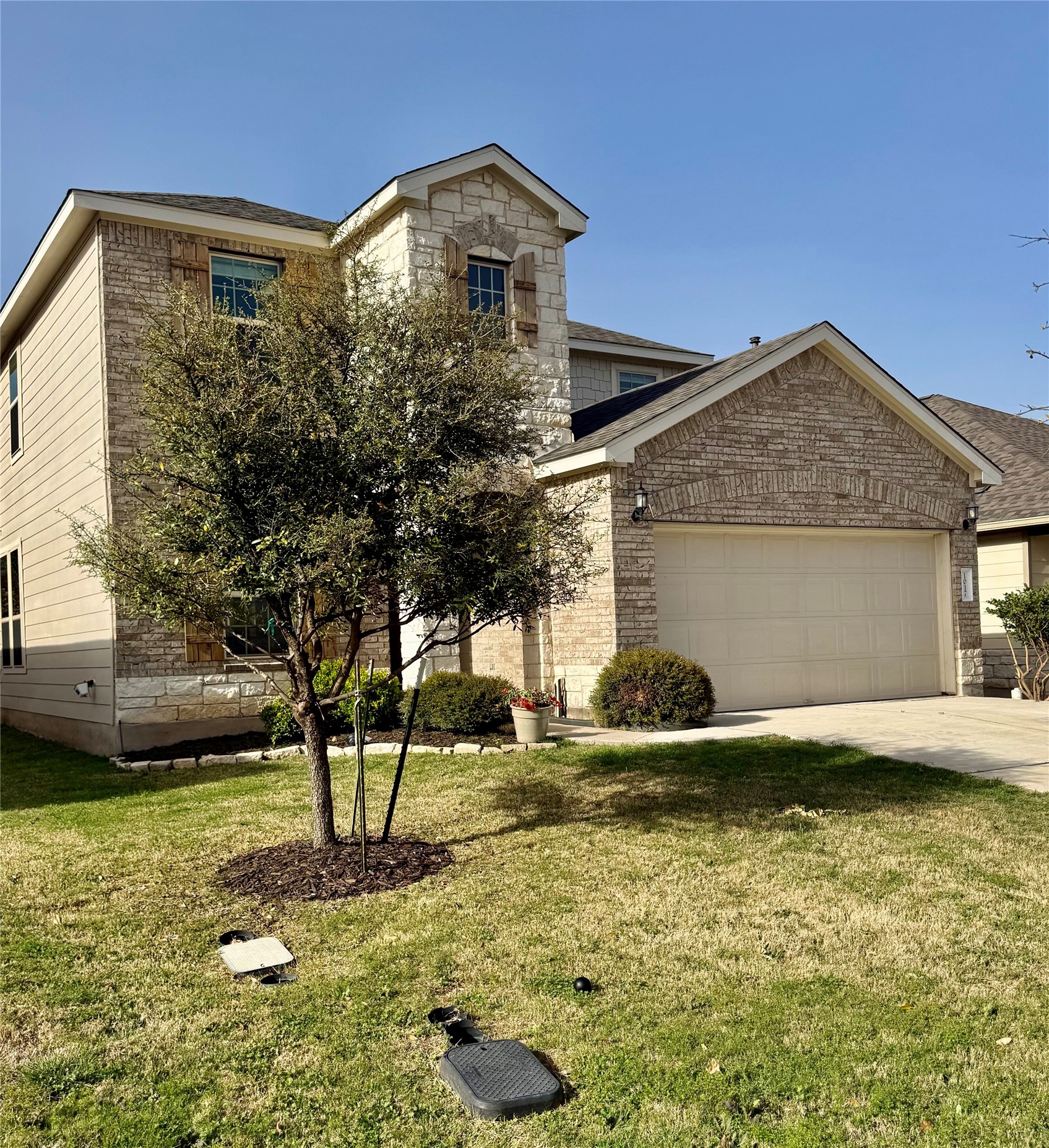 1017 Cliffbrake Way Georgetown, TX 78626 - Photo 3 of 21 View of front of house featuring a front lawn, an attached garage, driveway, and brick siding