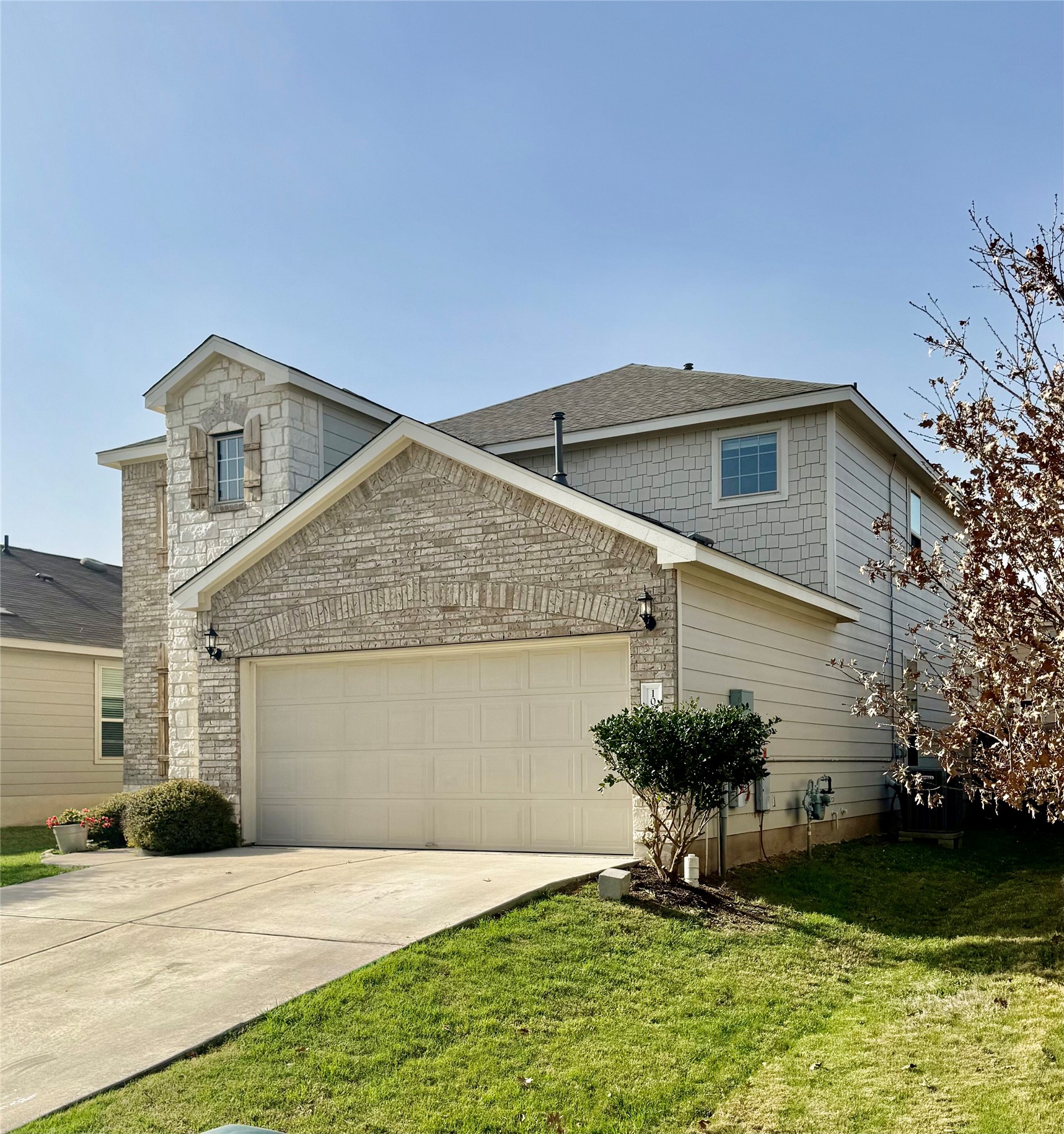 1017 Cliffbrake Way Georgetown, TX 78626 - Photo 4 of 21 Traditional-style home with a garage, concrete driveway, a front lawn, and brick siding
