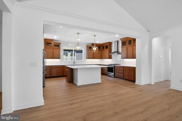 a large white kitchen with a large counter top and stainless steel appliances