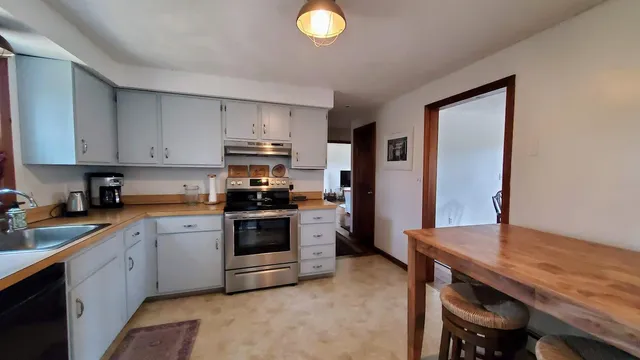 a kitchen with stainless steel appliances granite countertop a stove a sink dishwasher and a refrigerator