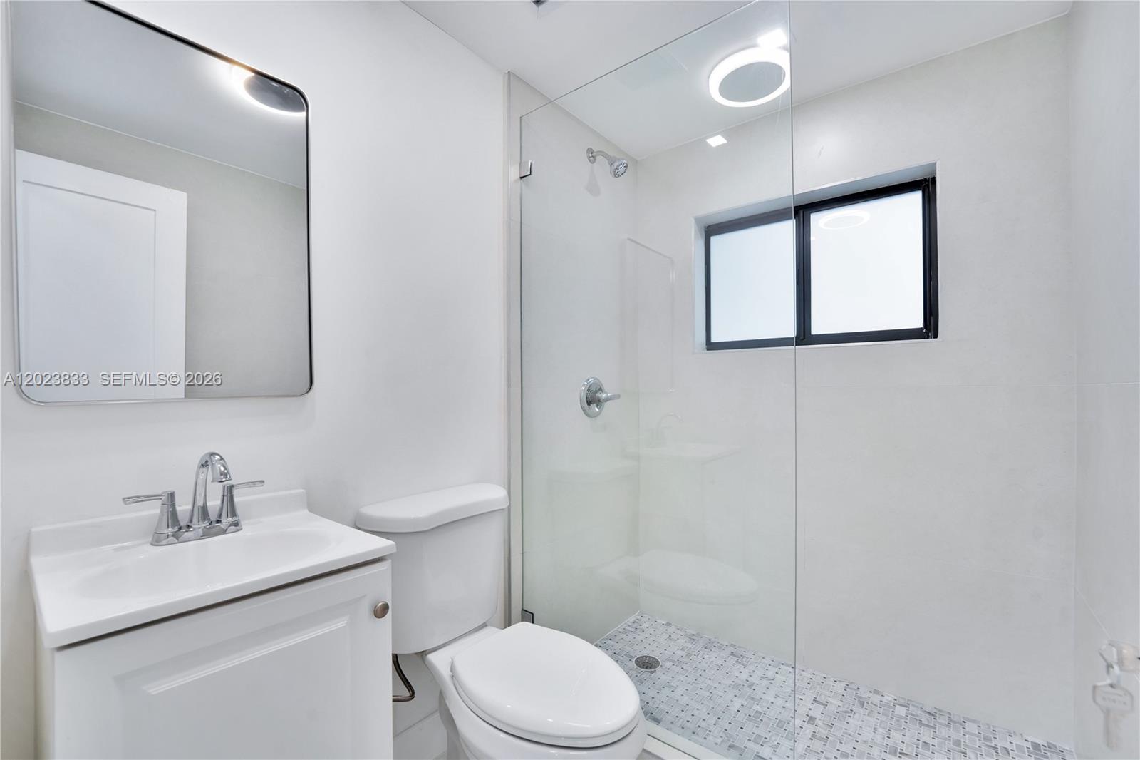 6566 Southwest 35th Street Miami, FL 33155 - Photo 18 of 36 a bathroom with a toilet sink shower and mirror