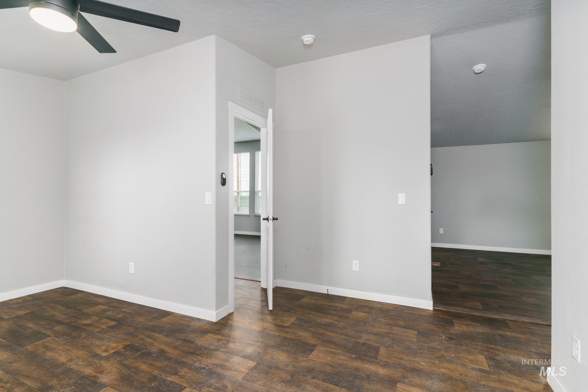 13678 North Hawthorne Road Pocatello, ID 83202 - Photo 16 of 37 Spare room with dark wood-style floors and a ceiling fan