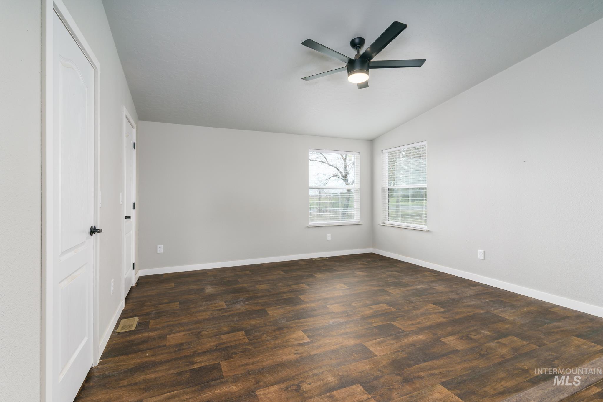 13678 North Hawthorne Road Pocatello, ID 83202 - Photo 26 of 37 Unfurnished bedroom featuring a closet, a ceiling fan, dark wood-type flooring, and vaulted ceiling