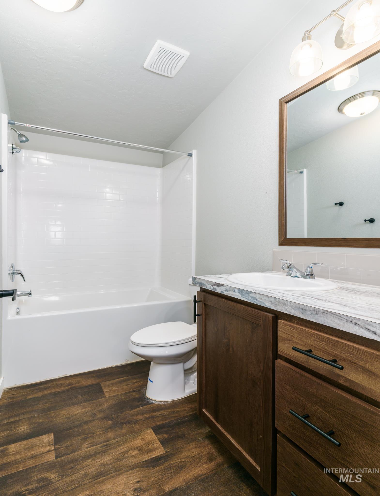 13678 North Hawthorne Road Pocatello, ID 83202 - Photo 27 of 37 Bathroom with vanity, shower / tub combination, and dark wood finished floors