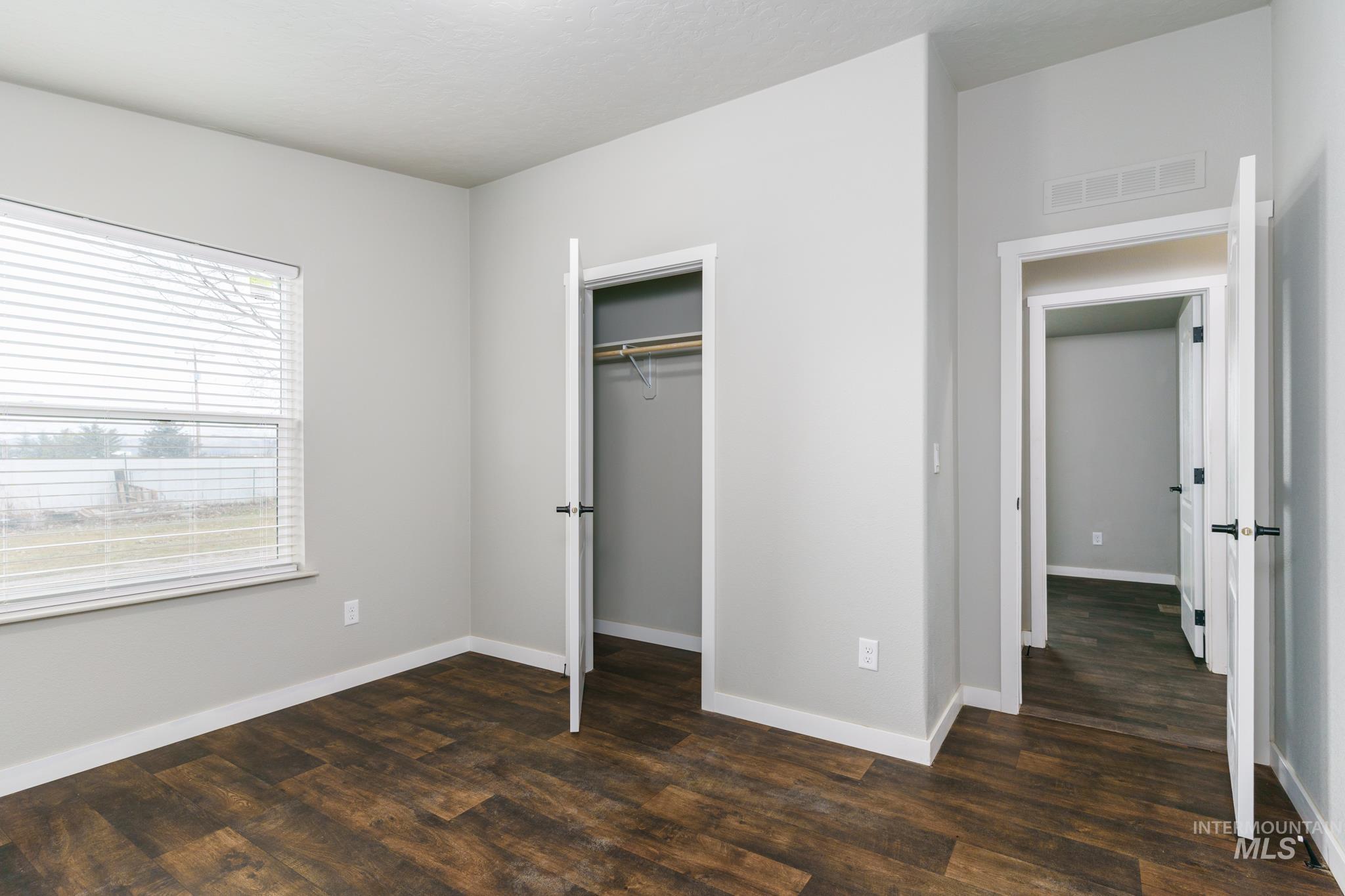 13678 North Hawthorne Road Pocatello, ID 83202 - Photo 29 of 37 Unfurnished bedroom with a closet and dark wood-style flooring