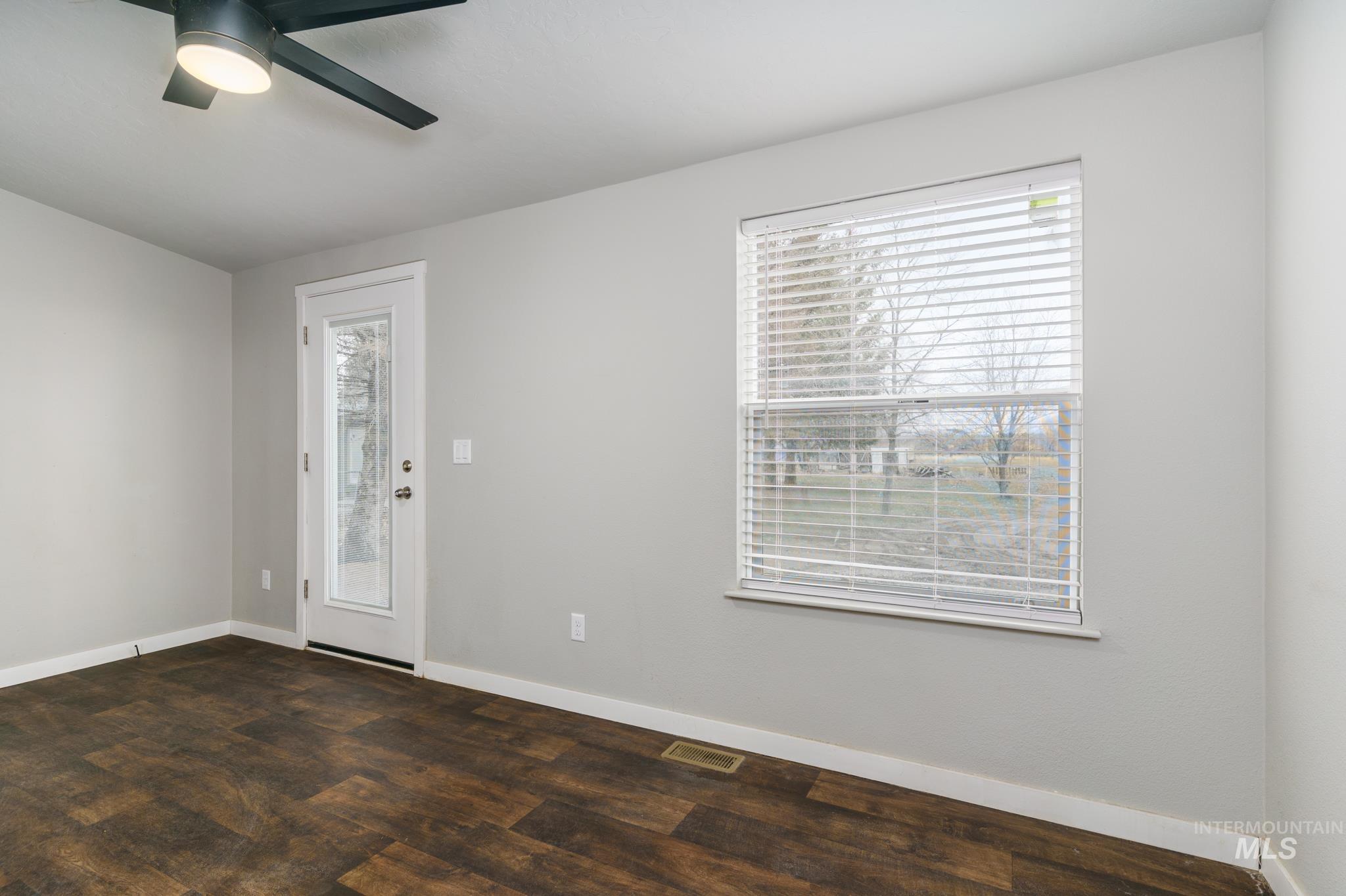 13678 North Hawthorne Road Pocatello, ID 83202 - Photo 30 of 37 Empty room with plenty of natural light, dark wood-style flooring, and a ceiling fan