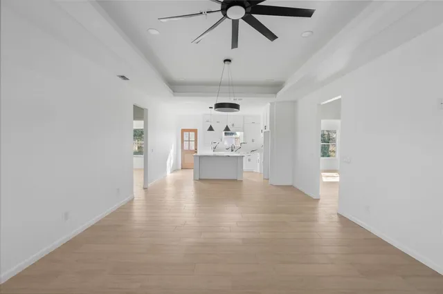 a big room with chandelier fan and windows