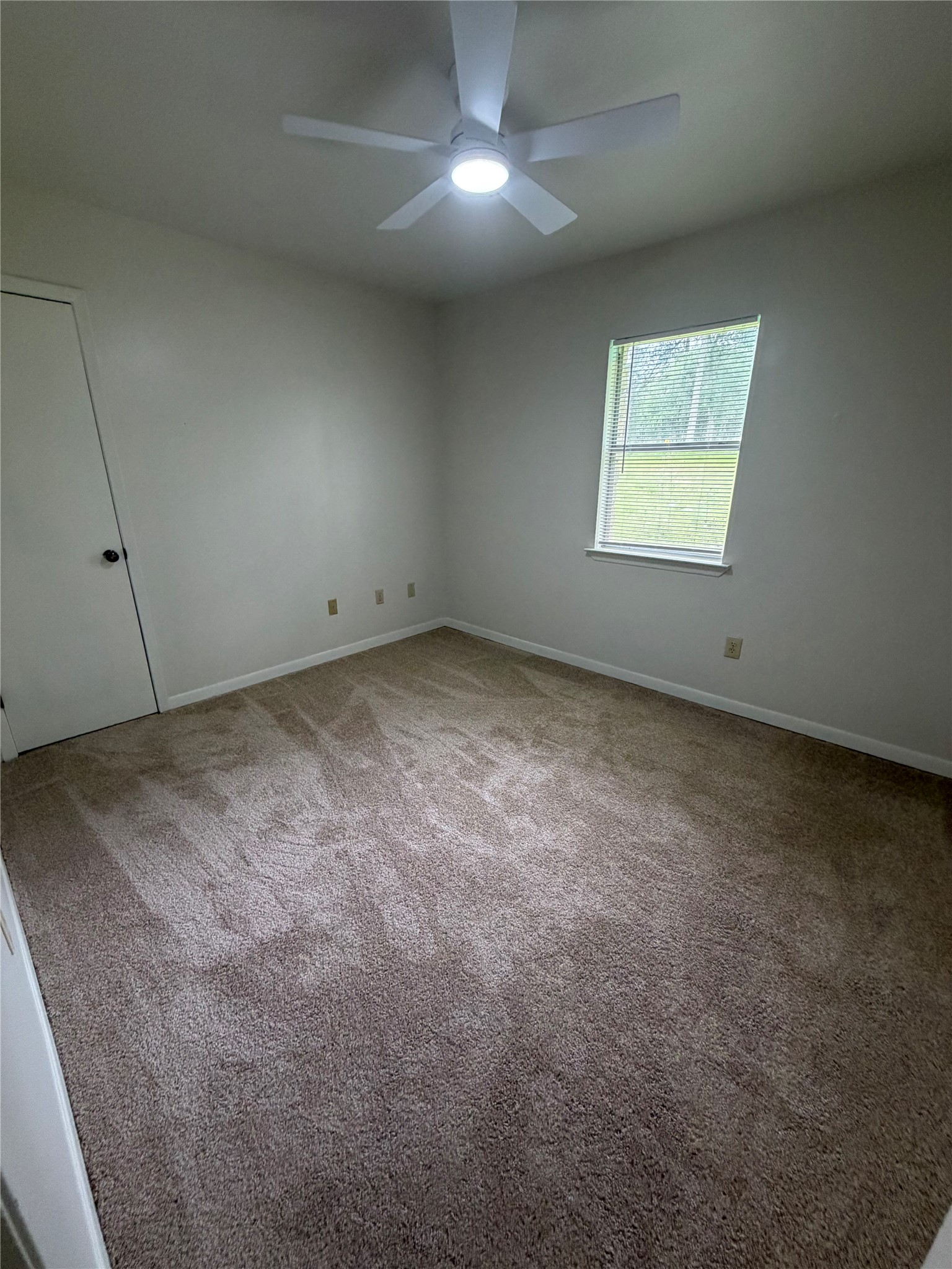 214 The Forest Road Dale, TX 78616 - Photo 10 of 18 A well-lit bedroom with fresh carpeting and a modern ceiling fan, ready for personal touches.