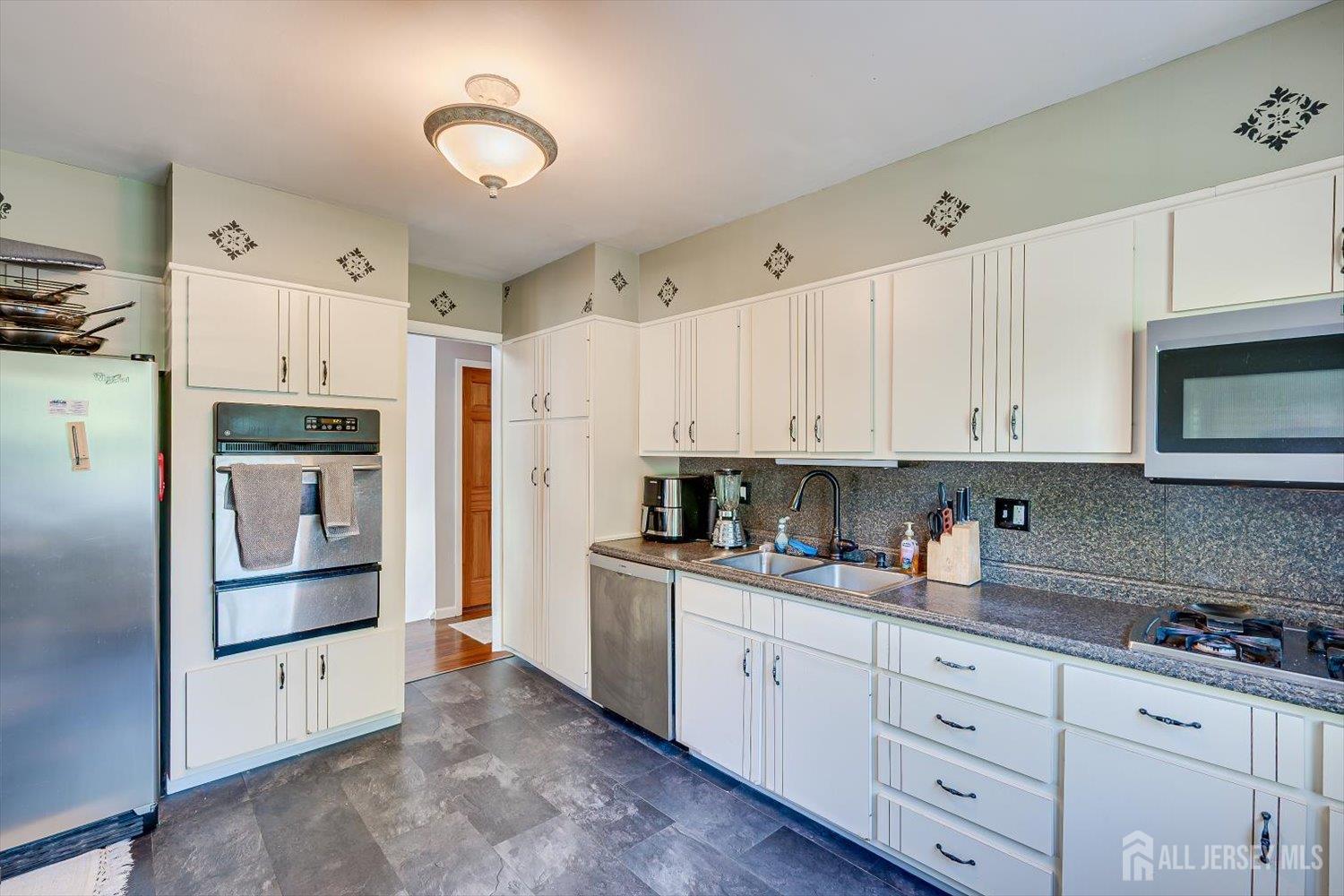 12 Gales Road Edison, NJ 08837 - Photo 13 of 35 a kitchen with granite countertop white cabinets and stainless steel appliances