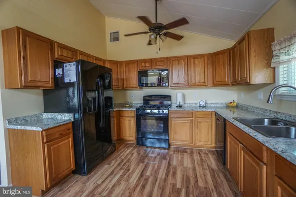 a kitchen with stainless steel appliances granite countertop a stove sink and microwave