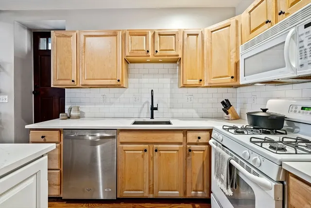 a kitchen with cabinets appliances and a sink