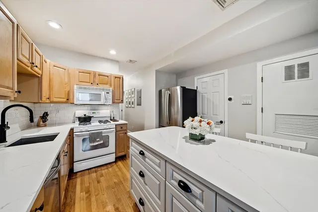 a kitchen with stainless steel appliances a sink stove refrigerator and cabinets