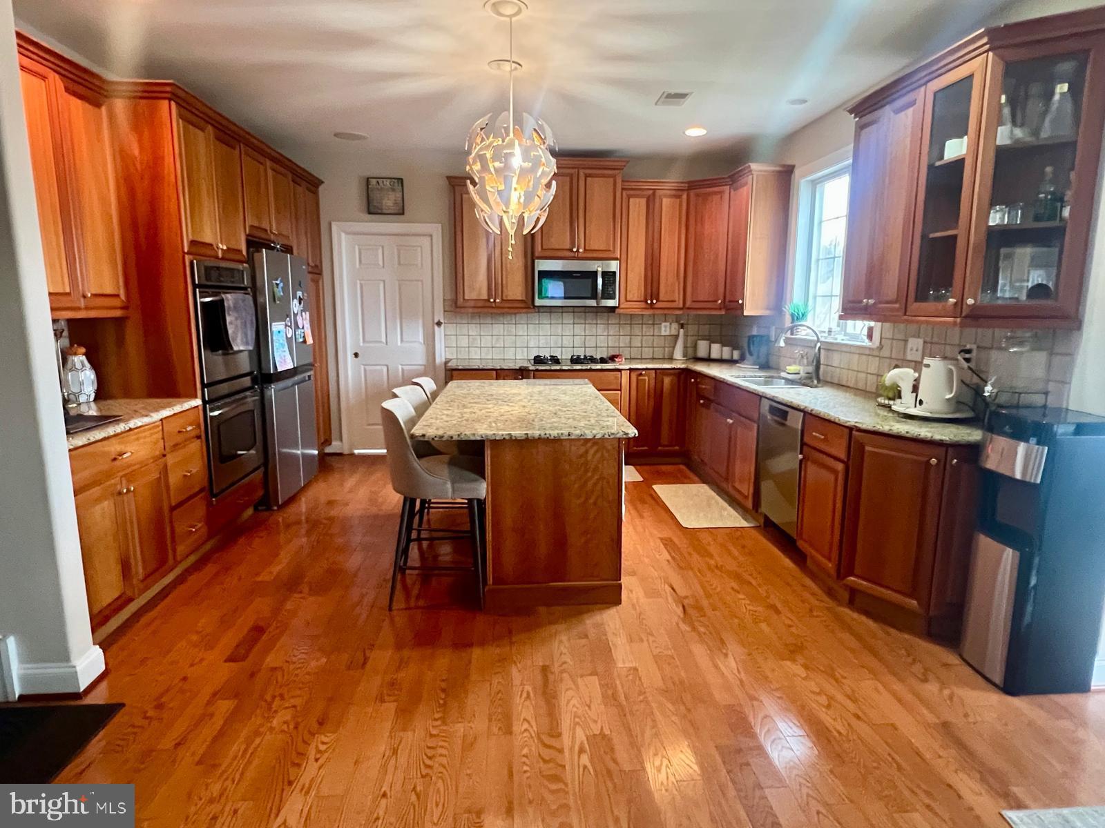 101 Richards Way Avondale, PA 19311 - Photo 15 of 45 a large kitchen with wooden floors a counter space and stainless steel appliances
