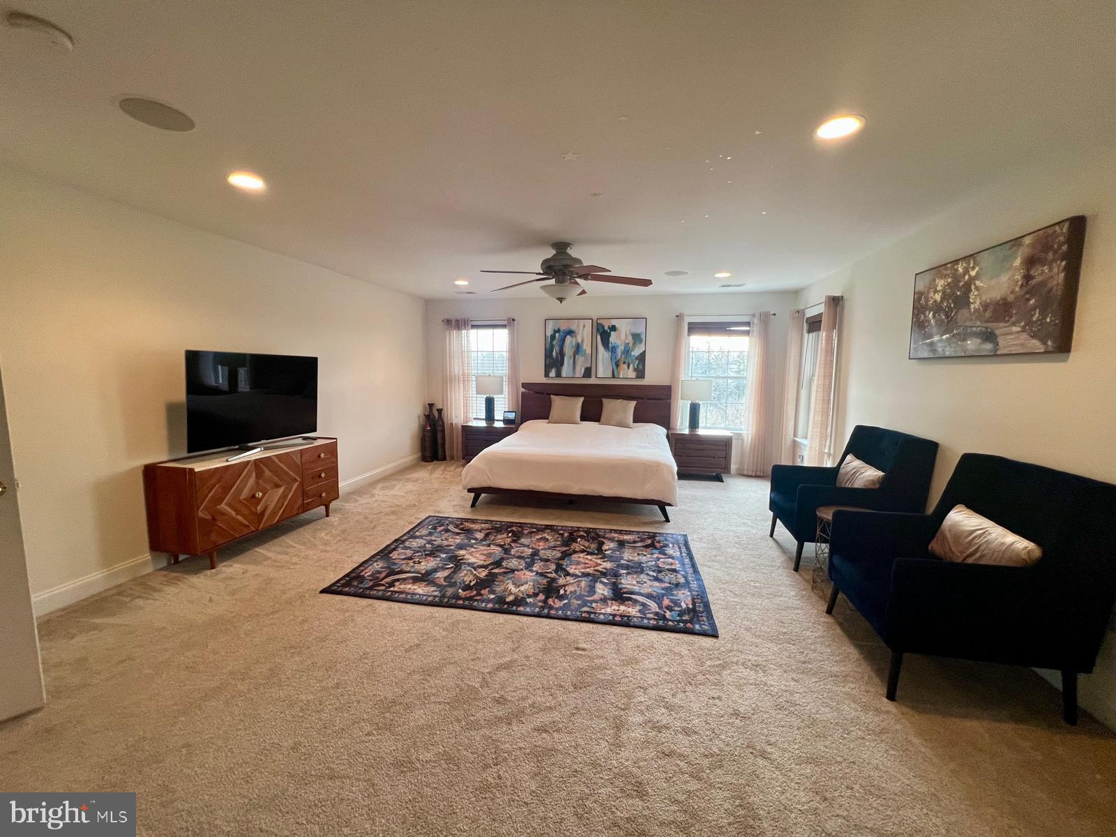 101 Richards Way Avondale, PA 19311 - Photo 25 of 45 a spacious bedroom with a bed a couch and a flat screen tv