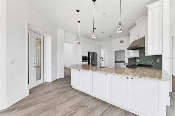 a large white kitchen with stainless steel appliances