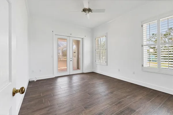 an empty room with wooden floor and windows