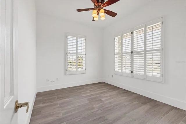 a view of an empty room with a window and wooden floor