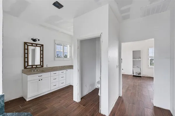 a room view with wooden floor and mirror