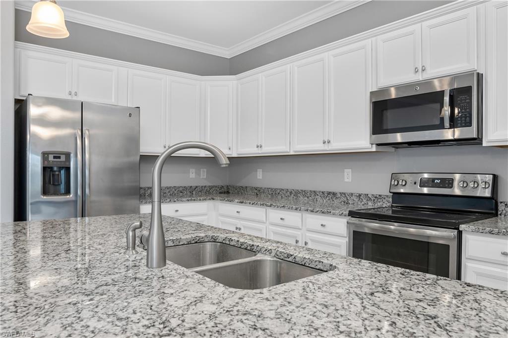 19952 Beverly Park Road Estero, FL 33928 - Photo 7 of 32 a kitchen with stainless steel appliances granite countertop a sink and a microwave