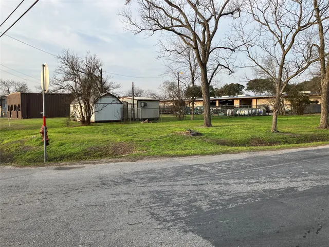 a view of a house with a big yard and large trees