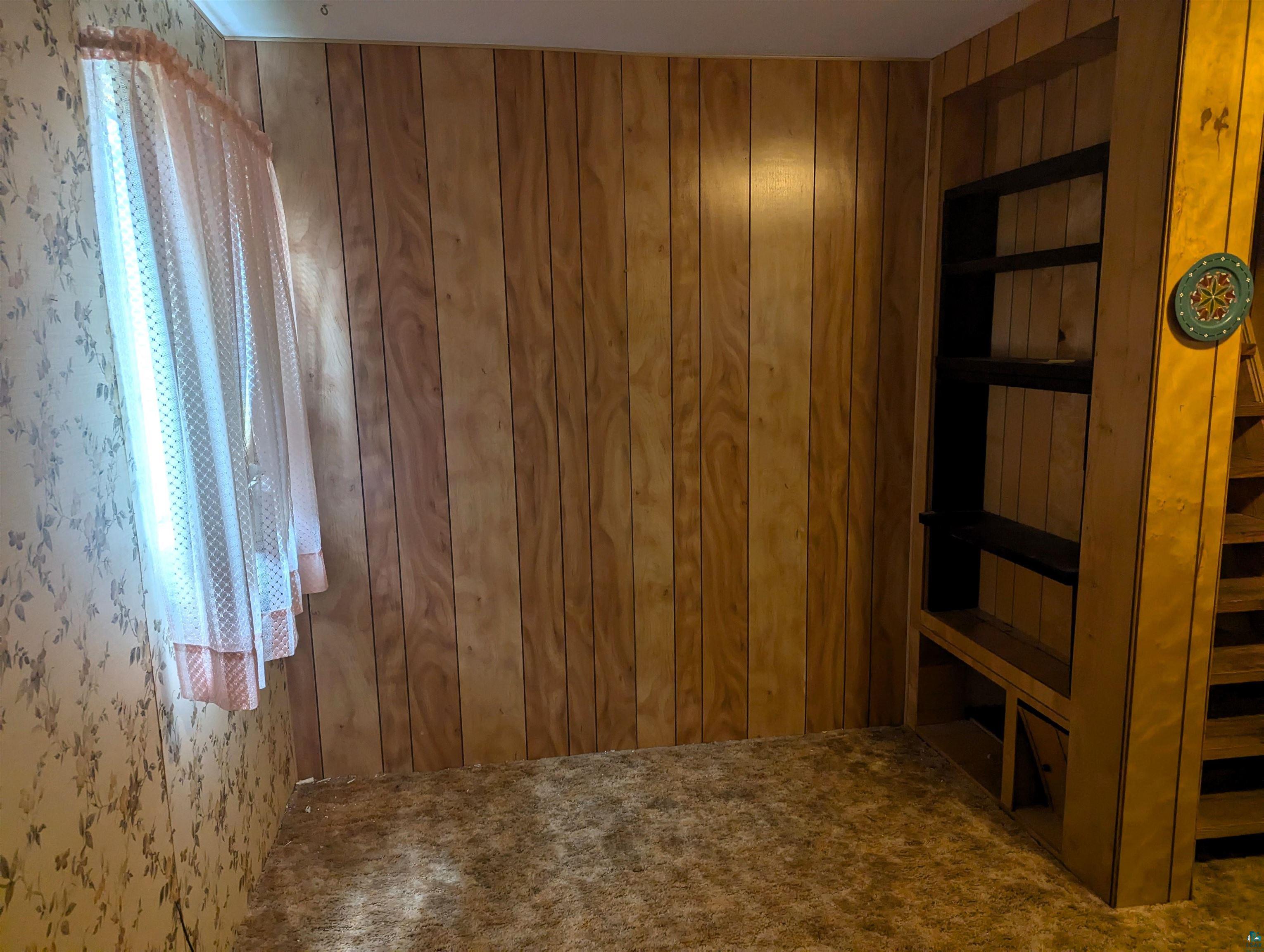 28 James Road Silver Bay, MN 55614 - Photo 20 of 37 Carpeted empty room featuring a wealth of natural light and wooden walls