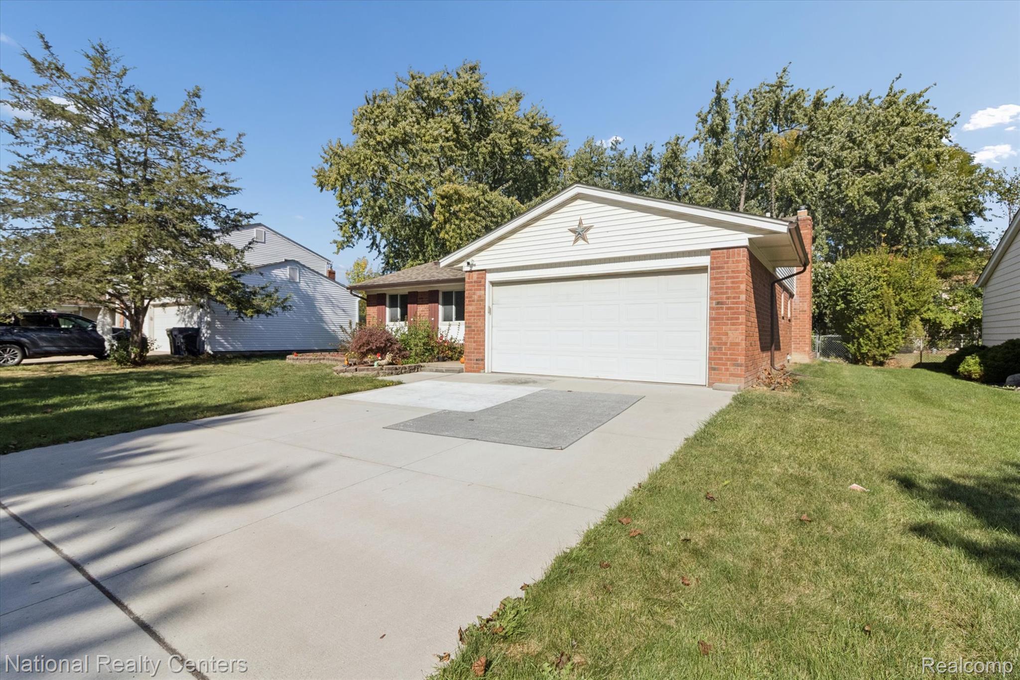 44768 Hanford Road Canton, MI 48187 - Photo 4 of 36 Ranch-style home with brick siding, a front yard, driveway, and a garage