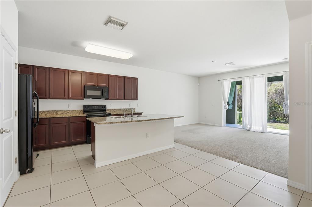 8986 Indigo Trail Loop Riverview, FL 33578 - Photo 8 of 28 a kitchen with stainless steel appliances a refrigerator sink and cabinets