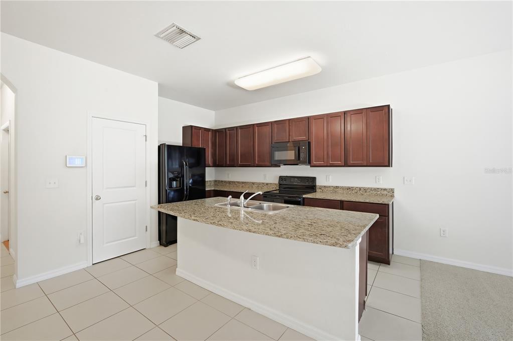 8986 Indigo Trail Loop Riverview, FL 33578 - Photo 9 of 28 a kitchen with stainless steel appliances granite countertop a sink stove and refrigerator