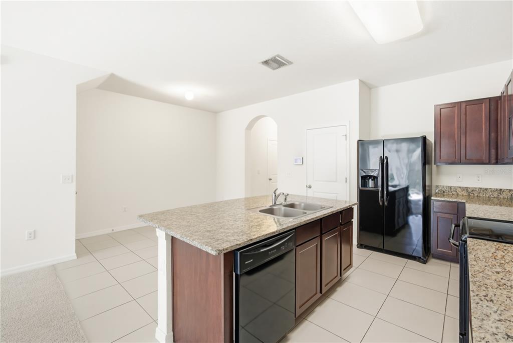 8986 Indigo Trail Loop Riverview, FL 33578 - Photo 10 of 28 a kitchen with a sink a refrigerator and cabinets