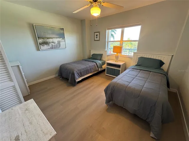 a bedroom with two beds and a potted plant