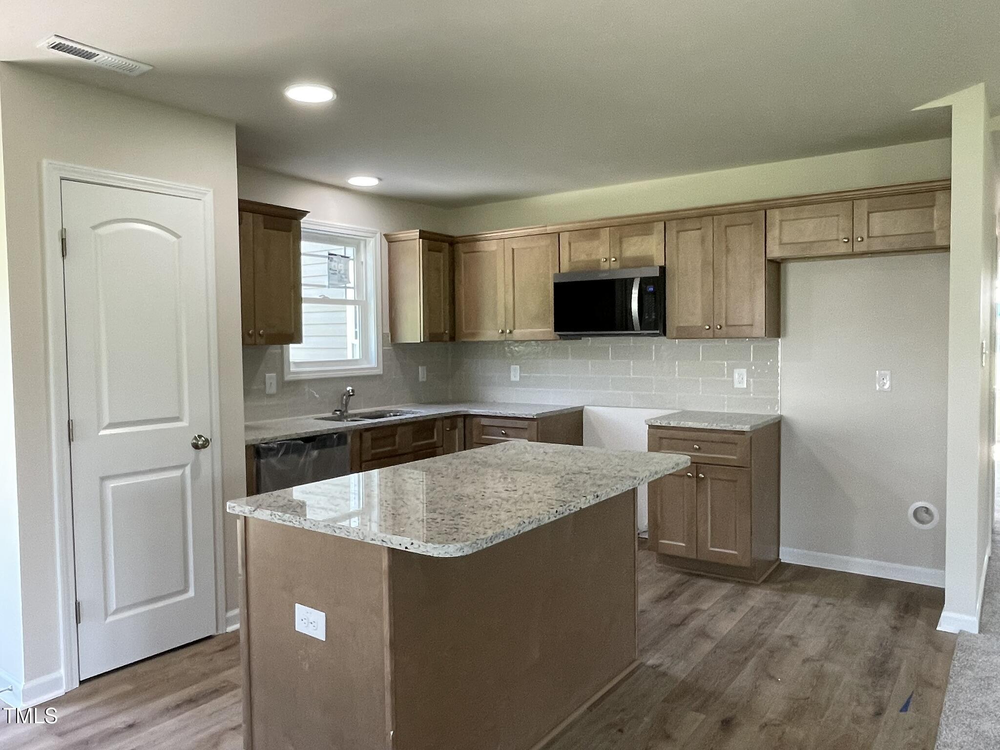 261 Phil Jack Road Dunn, NC 28334 - Photo 3 of 18 a kitchen with kitchen island a counter top space a sink stainless steel appliances and cabinets