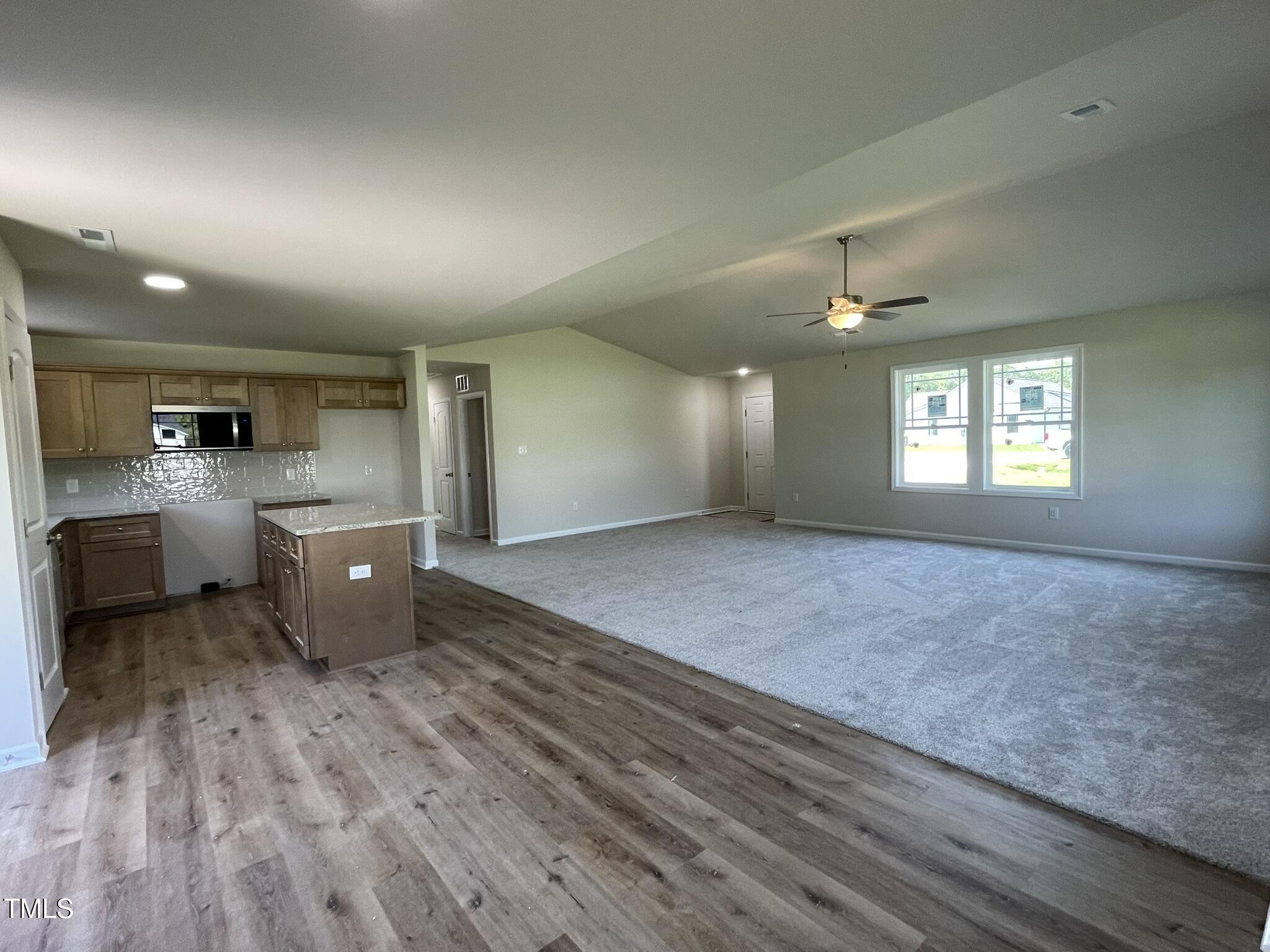 261 Phil Jack Road Dunn, NC 28334 - Photo 6 of 18 a open kitchen with kitchen island a sink dishwasher a stove and a refrigerator with wooden floor