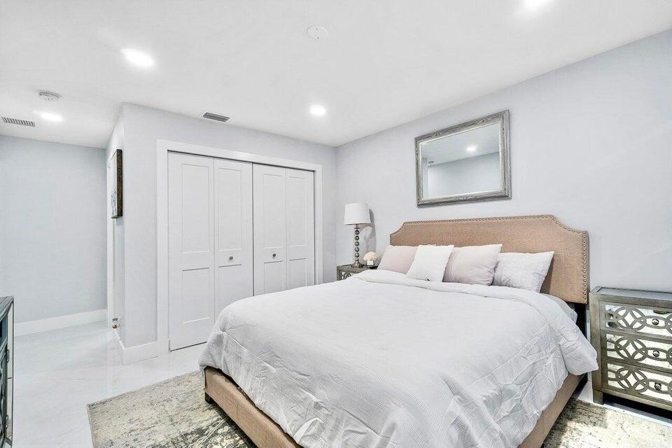 324 Bamboo Road Palm Beach Shores, FL 33404 - Photo 22 of 59 a spacious bedroom with a bed and a painting