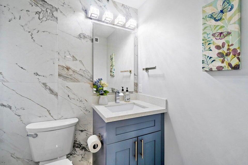 324 Bamboo Road Palm Beach Shores, FL 33404 - Photo 31 of 59 a bathroom with a sink a toilet and mirror