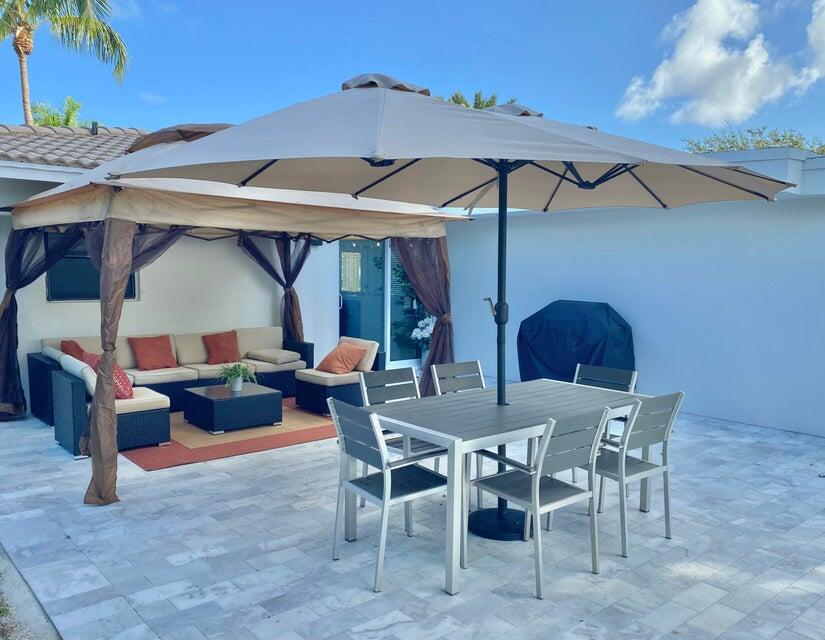 324 Bamboo Road Palm Beach Shores, FL 33404 - Photo 52 of 59 a view of a patio with a table and chairs