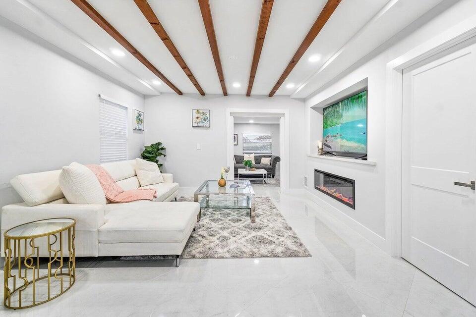 324 Bamboo Road Palm Beach Shores, FL 33404 - Photo 9 of 59 a living room with furniture wooden floor and a fireplace