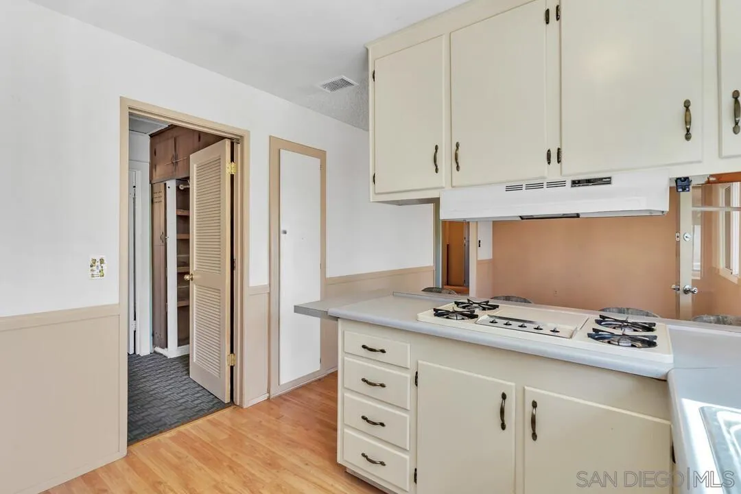9517 Abbeyfield Road Santee, CA 92071 - Photo 11 of 42 a hallway with cabinets and wooden floor