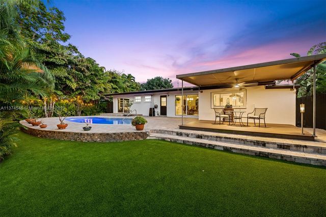 a front view of a house with a garden and swimming pool