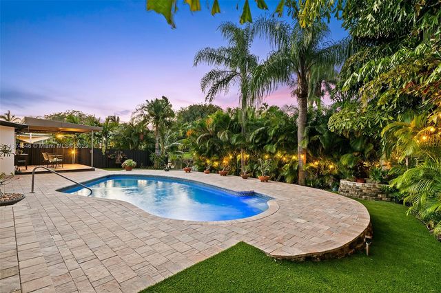 a view of a swimming pool with a yard and sitting area