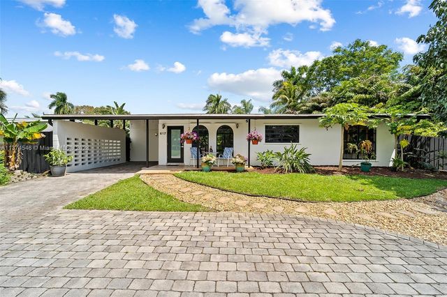 a front view of a house with a garden and yard