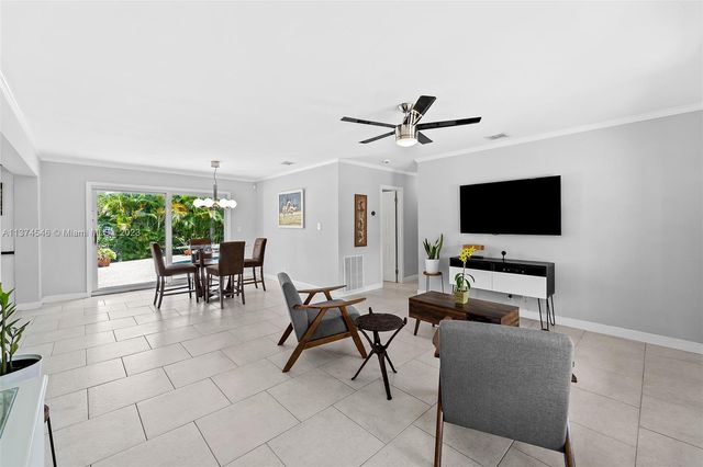 a living room with furniture a flat screen tv and a window