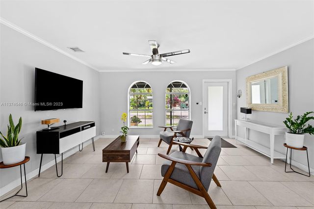 a living room with furniture a flat screen tv and a window