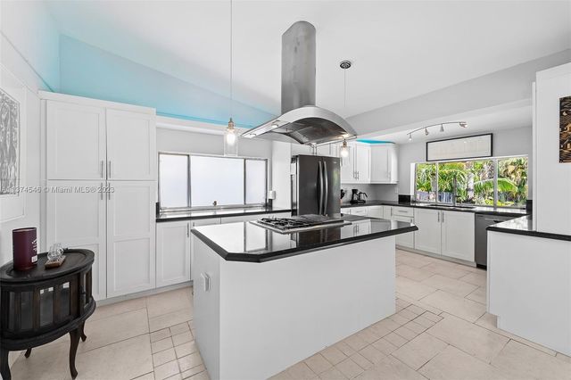 a kitchen with stainless steel appliances granite countertop a sink a stove and a refrigerator